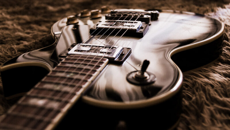 Guitarra marrom sobre um tapete